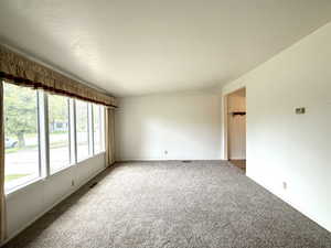 Unfurnished room featuring carpet flooring and visible vents