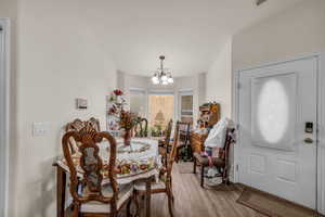Dining room with baseboards, an inviting chandelier, and wood finished floors