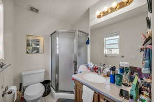 Full bath featuring vanity, a stall shower, toilet, and visible vents