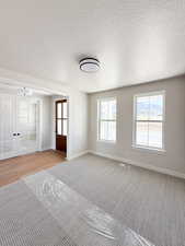 Interior space featuring visible vents, baseboards, french doors, and light colored carpet