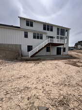 Back of house with a wooden deck and stairs