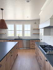 Kitchen with appliances with stainless steel finishes, dark countertops, and tasteful backsplash