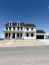 View of front facade featuring an attached garage, board and batten siding, a standing seam roof, covered porch, and metal roof