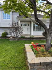View of front of house featuring flowerbed and front entrance