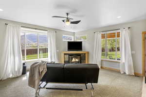 Living area featuring carpet floors, ceiling fan