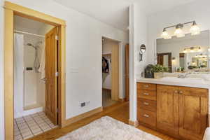 Full bathroom featuring vanity, a shower with curtain, wood finished floors, and walk in closet