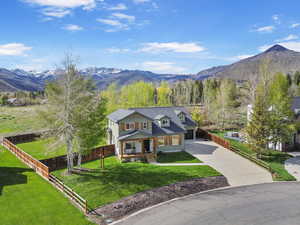 Aerial shot with a mountain view, oversized driveway, covered front porch
