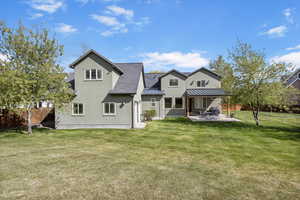 Rear view of property featuring a fenced backyard, a lawn, a patio, and a standing seam roof