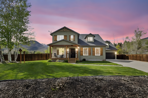 View of front of property with fence, covered porch, concrete driveway, and a front yard