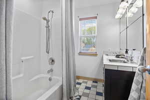 Bathroom featuring tile patterned flooring, shower / tub combo, and vanity