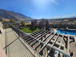 View of swimming pool with a fenced in pool, a mountain view, a fenced backyard, a yard, and a water slide