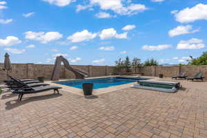 View of swimming pool with a diving board, a fenced in pool, a fenced backyard, a patio, and a water slide