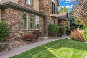 View of home's exterior featuring a yard and stone siding