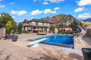 View of swimming pool with a pergola, a water slide, a mountain view, and a fenced in pool