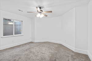 Unfurnished room with carpet floors, ceiling fan, visible vents, and baseboards