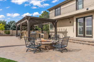 View of patio / terrace with fence, a pergola, an outdoor fire pit, area for grilling, and a balcony