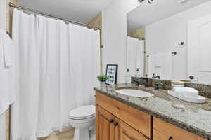 Bathroom with vanity, visible vents, toilet, a shower with shower curtain, and tile patterned floors