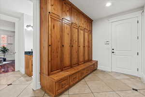 Mudroom with light tile patterned floors, baseboards, and recessed lighting