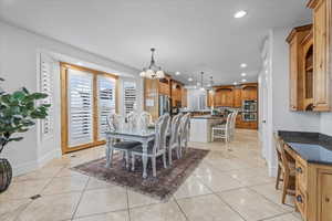 Dining room with recessed lighting, baseboards, light tile patterned floors, and an inviting chandelier