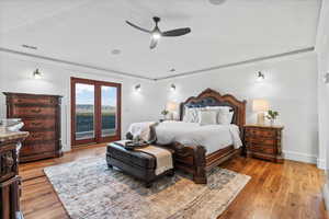 Bedroom with light wood-style floors, ornamental molding, a ceiling fan, and visible vents