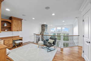 Living area featuring crown molding, recessed lighting, baseboards, and light wood-style floors