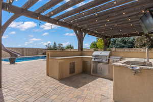View of patio with area for grilling, a fenced in pool, a fenced backyard, a pergola, and a grill