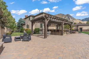 View of patio with fence private yard, a pergola, an outdoor hangout area, outdoor dry bar, and a mountain view