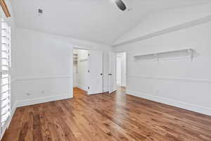 Unfurnished bedroom with baseboards, ceiling fan, wood finished floors, and lofted ceiling