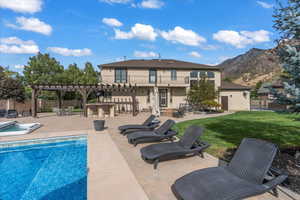 Back of house with fence, outdoor dry bar, a pergola, and stucco siding