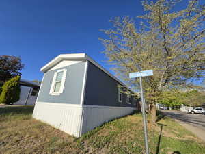 View of side of home featuring a yard