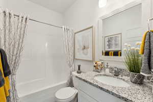 Full bathroom featuring vanity, shower / bath combo with shower curtain, and toilet