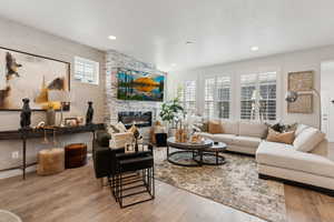 Living room with plenty of natural light, recessed lighting, wood finished floors, and a fireplace