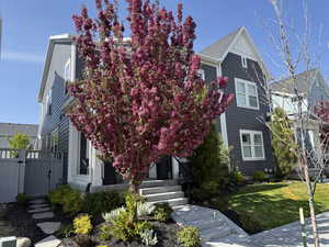 View of front of home with fence, a gate, and a front lawn