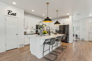 Kitchen featuring recessed lighting, visible vents, and fridge with ice dispenser
