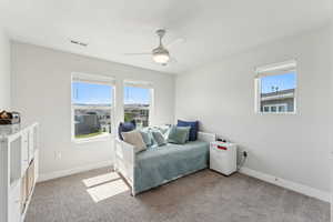Bedroom featuring visible vents, baseboards, multiple windows, and light colored carpet