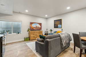 Living area featuring recessed lighting, baseboards, visible vents, and light wood-type flooring