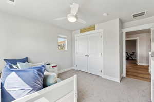 Bedroom featuring baseboards, light carpet, a closet, and visible vents