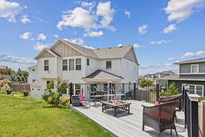 Rear view of house featuring board and batten siding, a fire pit, a deck, and a shingled roof