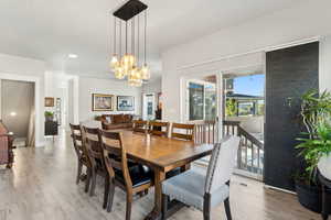 Dining area featuring a notable chandelier, light wood-type flooring, and visible vents