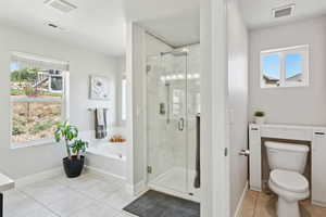 Full bath featuring visible vents, tile patterned flooring, toilet, a bath, and a marble finish shower