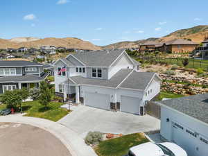 View of front of property with a mountain view, concrete driveway, a residential view, and a shingled roof