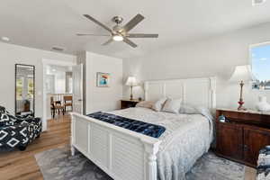 Bedroom with ceiling fan, visible vents, and light wood-type flooring