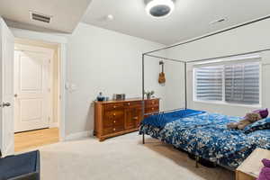 Bedroom with light colored carpet and visible vents