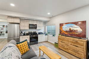 Kitchen with a sink, stainless steel appliances, recessed lighting, light wood-type flooring, and modern cabinets