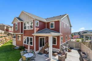 Rear view of property featuring board and batten siding, roof with shingles, a patio area, a fenced backyard, and outdoor lounge area