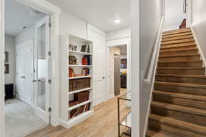 Stairs featuring visible vents, radiator heating unit, and wood finished floors