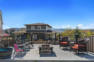 Wooden deck with a fire pit and a mountain view