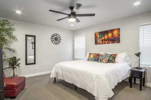 Large primary bedroom with ample space for seating area features cut and loop carpet, wide baseboards, recessed lighting, ceiling fan with light, large walk-in closet and a beautiful spa style ensuite.