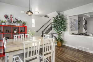 Comfortable dining area featuring LVP floors, balcony access, stairway to third level with metal handrails