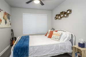Bedroom #2 featuring large window with custom fit vinyl blinds, cut and loop carpet, ceiling fan with light, ample closet space and wide baseboards